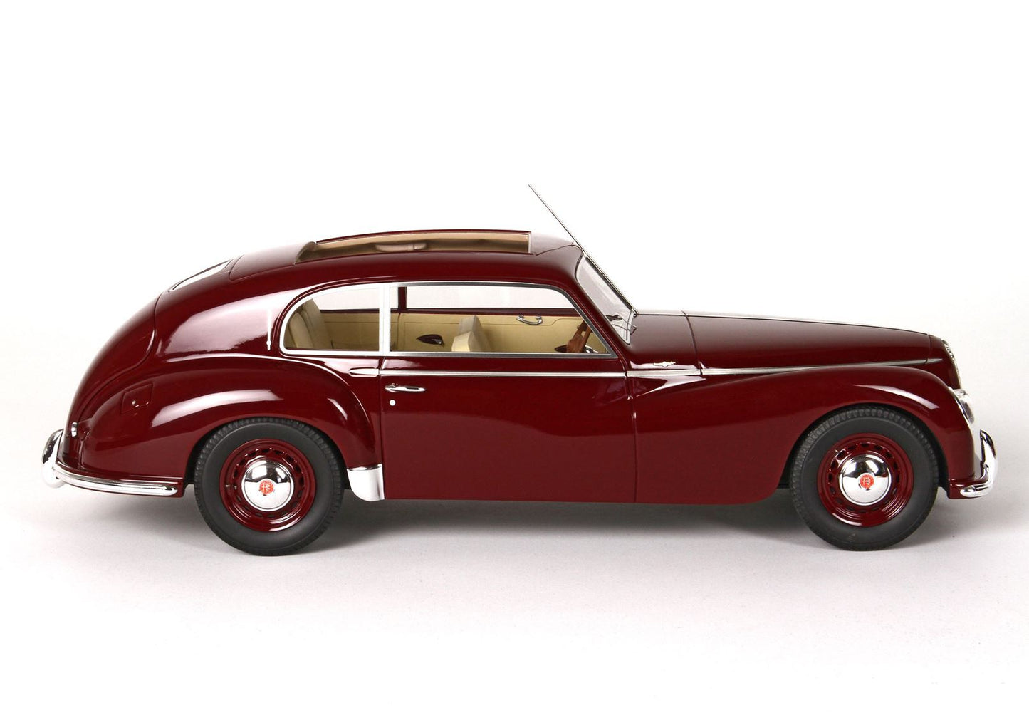 Side view of vintage maroon classic car with beige interior, showcased and available on Vroomi platform