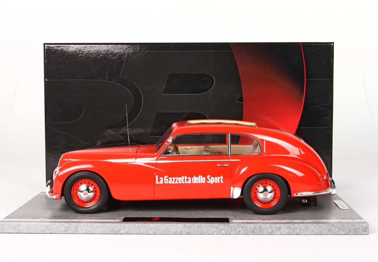 Red La Gazzetta dello Sport classic model car on display stand with branded black-red backdrop, available on Vroomi