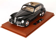 Black vintage model car with beige interior displayed on a brown leather base, available on Vroomi