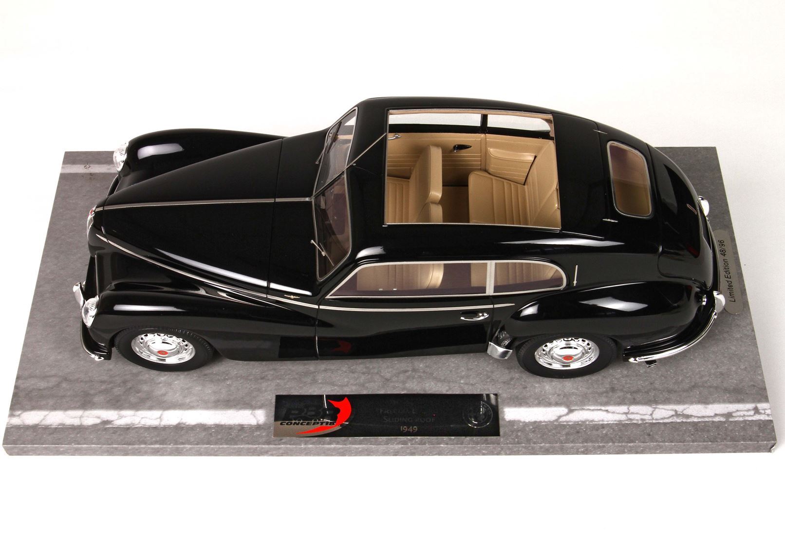 Black 1949 classic car model with beige interior on display base, available on Vroomi