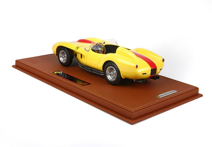 Yellow Ferrari model car with red stripe displayed on brown leather base, now offered on Vroomi