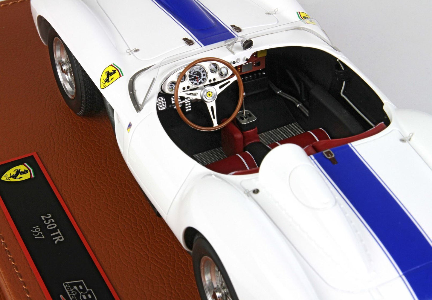 White 1957 Ferrari 250 TR model car with blue racing stripe and red seats available on Vroomi