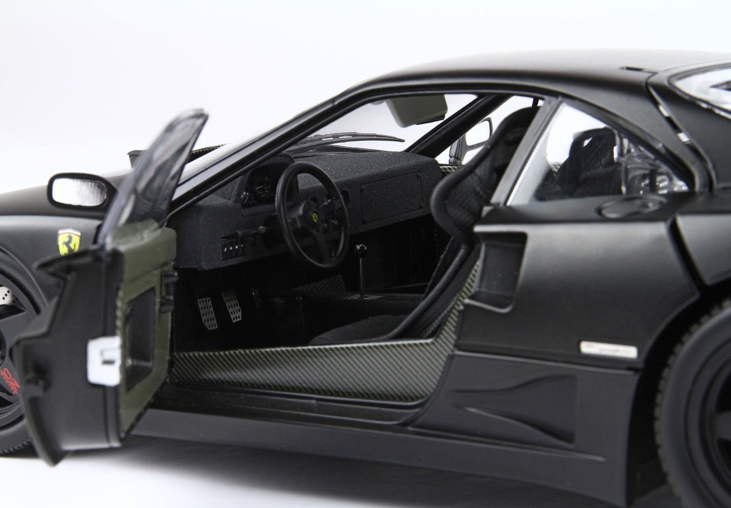 Open driver door of black Ferrari F40 showing carbon fiber interior and racing seats, available on Vroomi