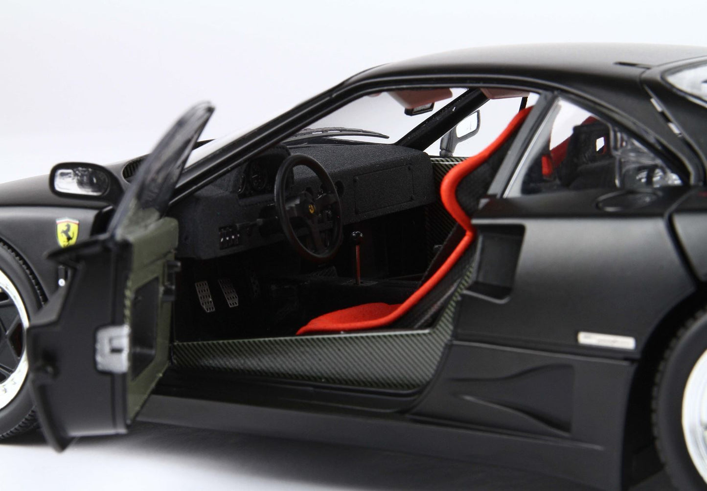 Black Ferrari sports car with open door showing red racing seat and carbon fiber interior, available on Vroomi