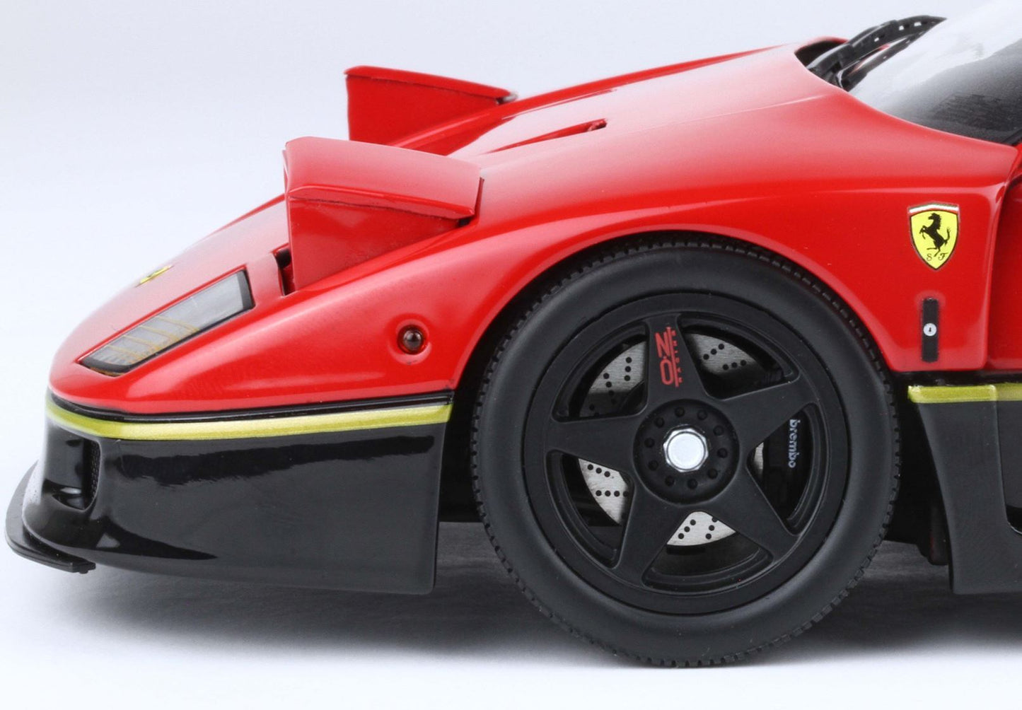 Close-up of red Ferrari model front side with black wheel and Brembo brake, available via Vroomi