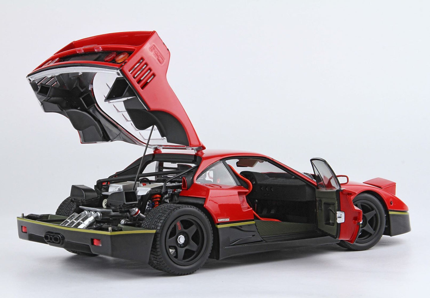 Red and black sports car model with open rear hood and driver door showing engine and interior, available on Vroomi