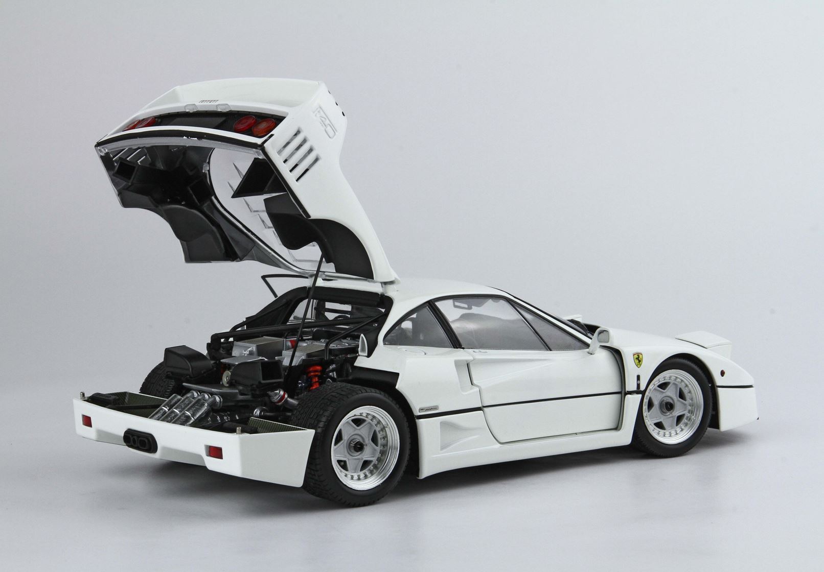 White Ferrari F40 sports car with open rear hood showing engine, available through Vroomi