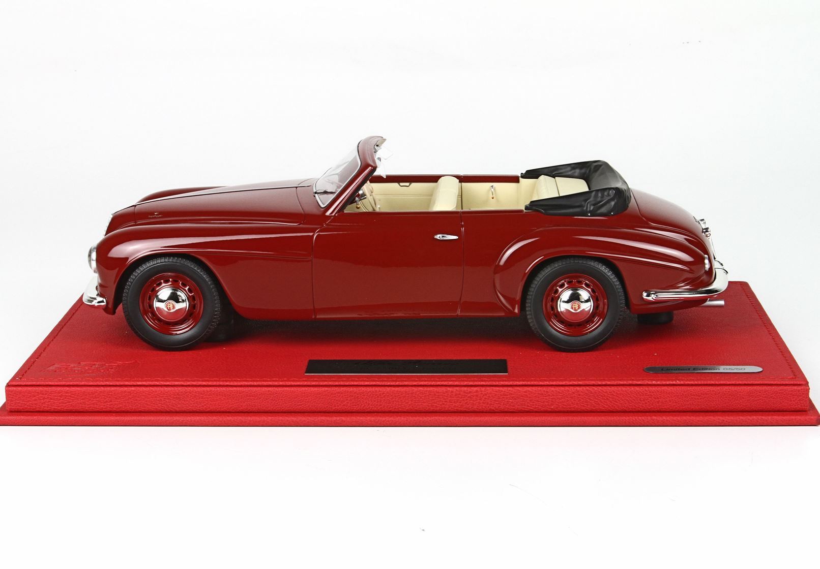 Classic red convertible model car with cream interior on red display base, available on Vroomi