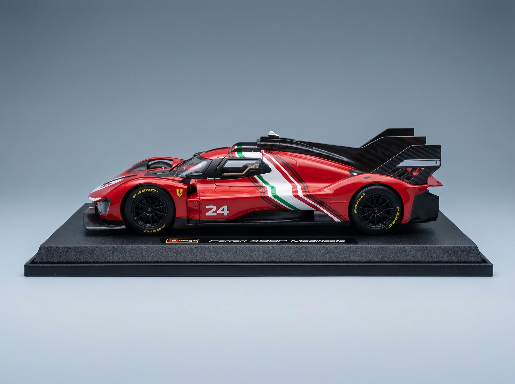 Rotes Ferrari 499P Modificata-Modellauto mit italienischen Streifen, präsentiert auf einem schwarzen Sockel bei Vroomi