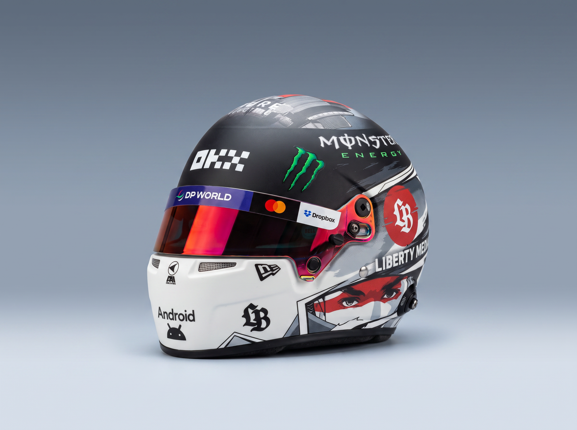 Scale model car racing helmet with Monster Energy, DP World, and Liberty Media logos, featured by Vroomi
