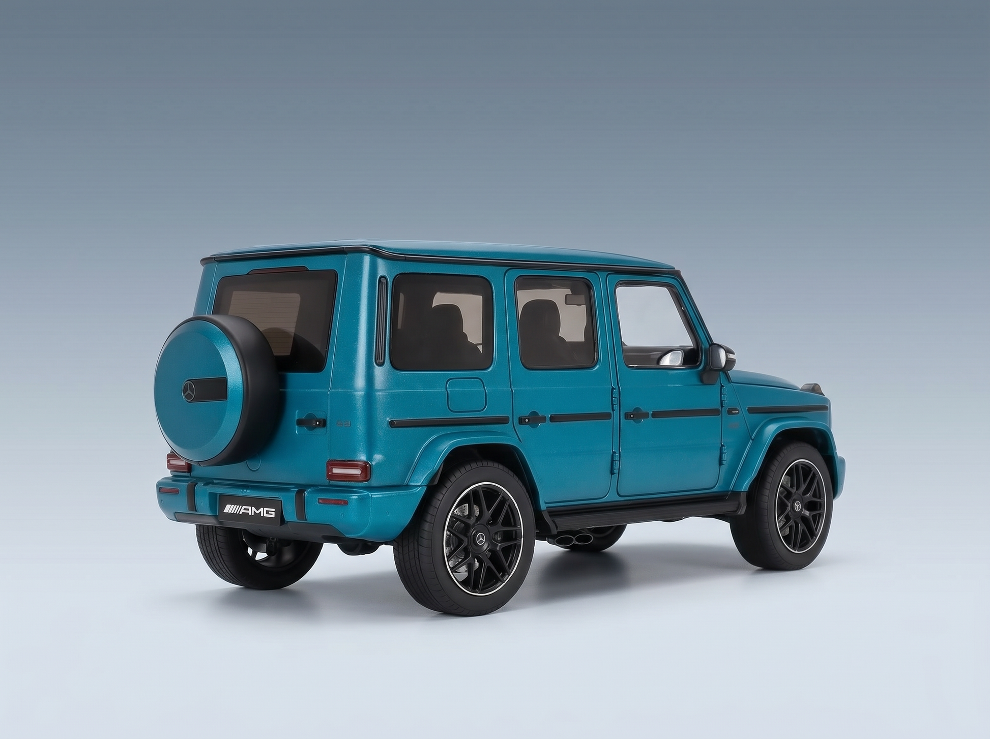 Tealfarbenes Mercedes-AMG G63-Modellauto von Vroomi, detailgetreue Druckguss-Nachbildung mit schwarzen Rädern und Reserverad am Heck.
