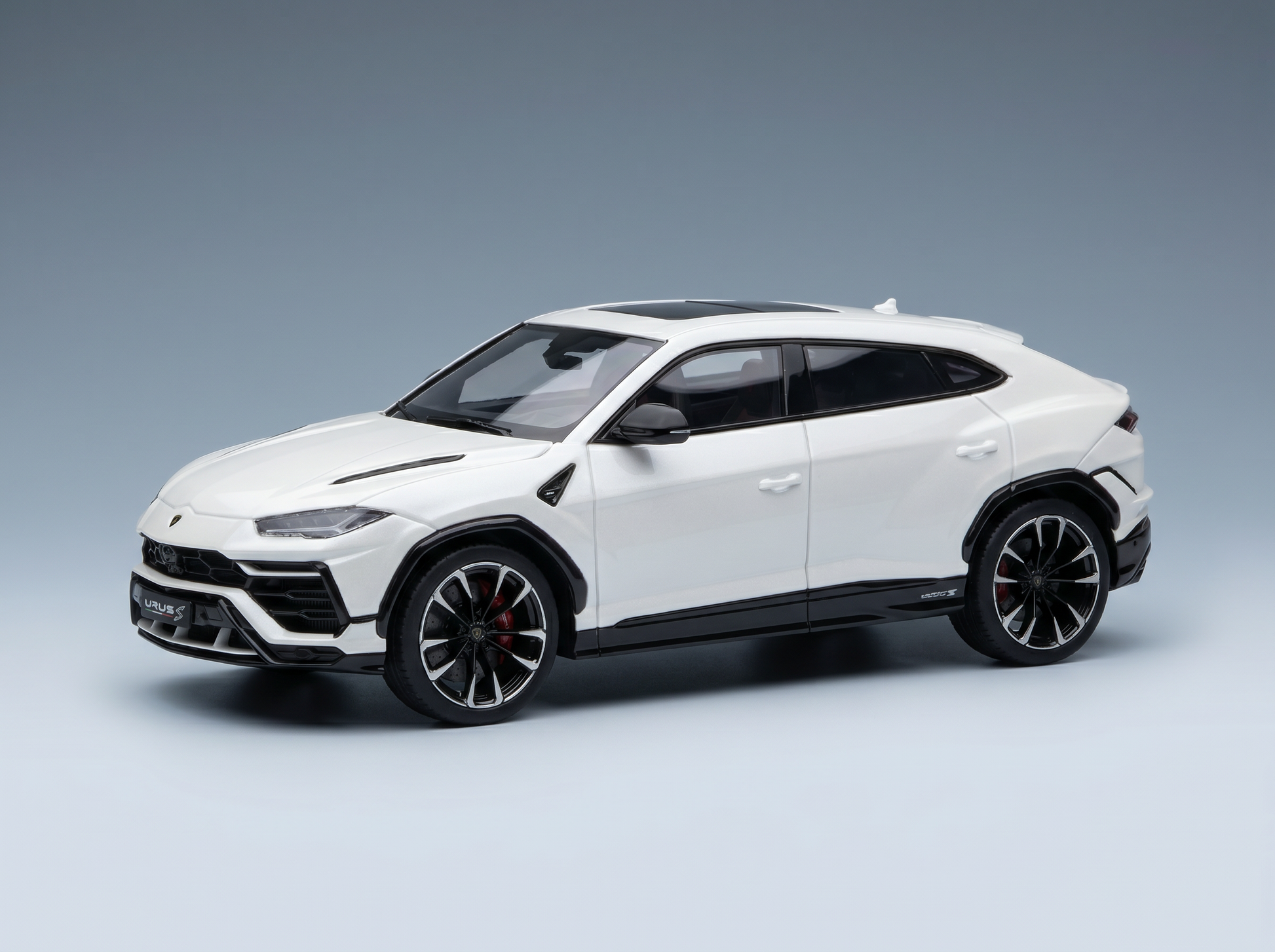 Weißes Lamborghini Urus S-Modellauto im Maßstab mit schwarzen Akzenten, präsentiert für Vroomi-Sammler