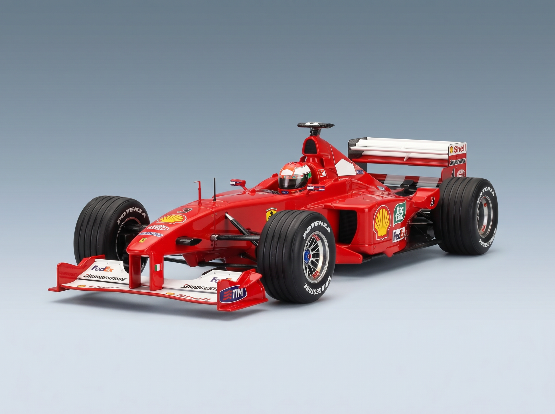 Maquette de voiture de Formule 1 Ferrari rouge arborant les logos Shell, FedEx et Bridgestone, présentée par Vroomi à l'intention des collectionneurs.