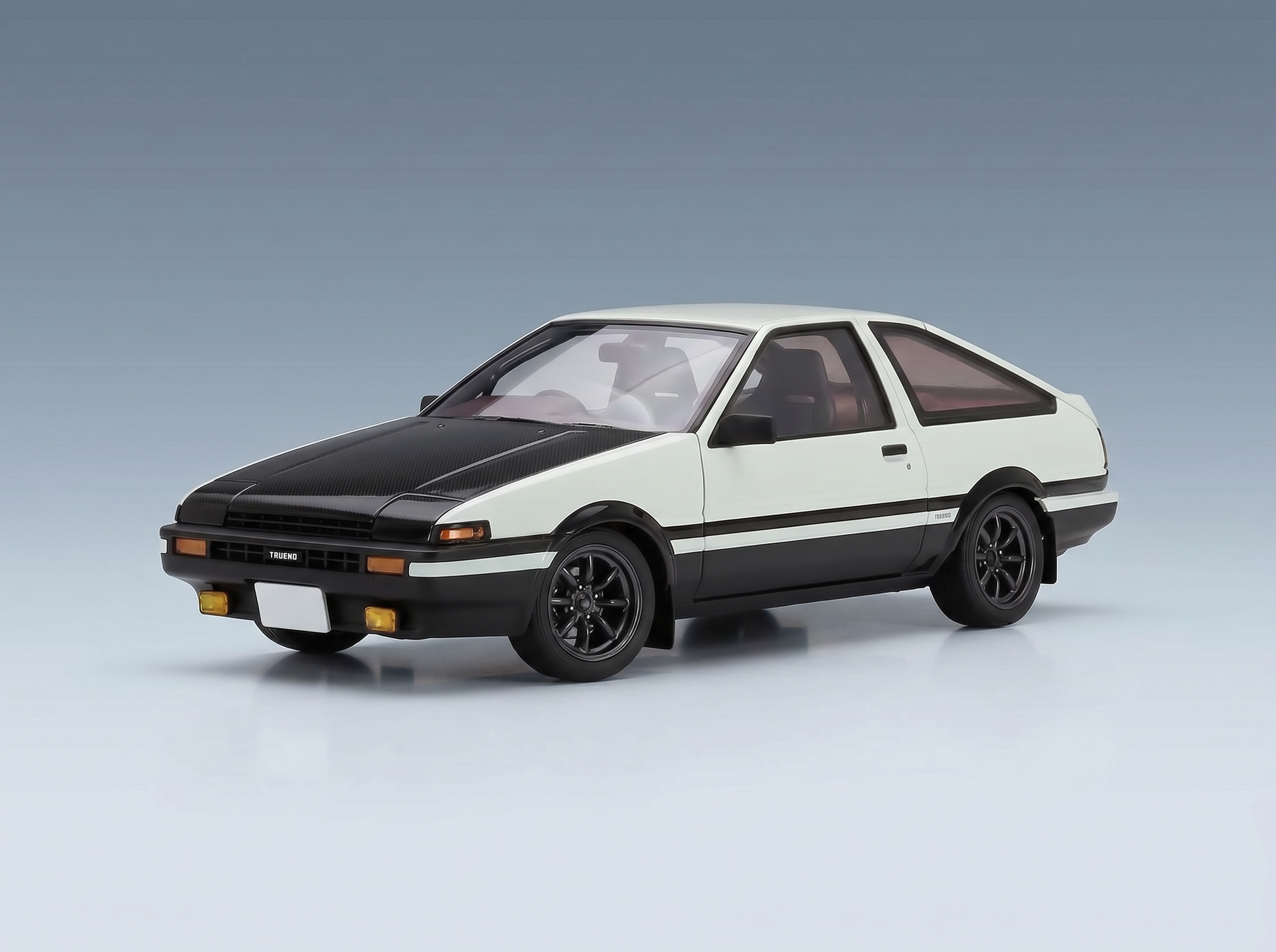 Weißes und schwarzes AE86 Trueno-Modellauto von Vroomi mit Motorhaube aus Carbonfaser und elegantem Design.