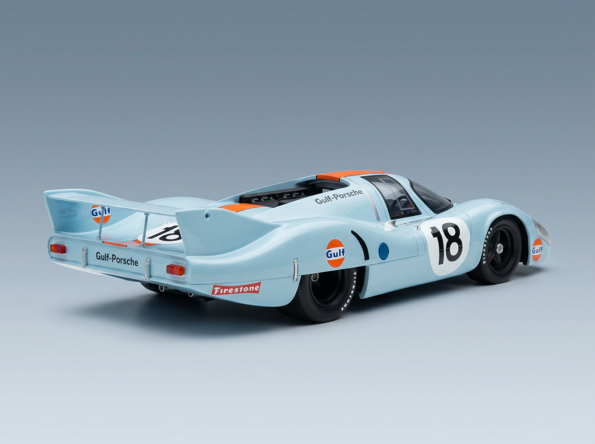 Gulf-Porsche-Modellauto im Maßstab 1:18 in Hellblau mit orangefarbenen Akzenten, präsentiert von Vroomi für Sammler.