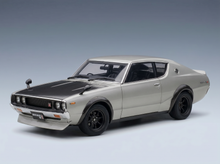 Silbernes Modellauto mit schwarzen Akzenten, präsentiert von Vroomi für Sammler und Motorsportfans.