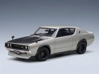 Silbernes Modellauto mit schwarzen Akzenten, präsentiert von Vroomi für Sammler und Motorsportfans.
