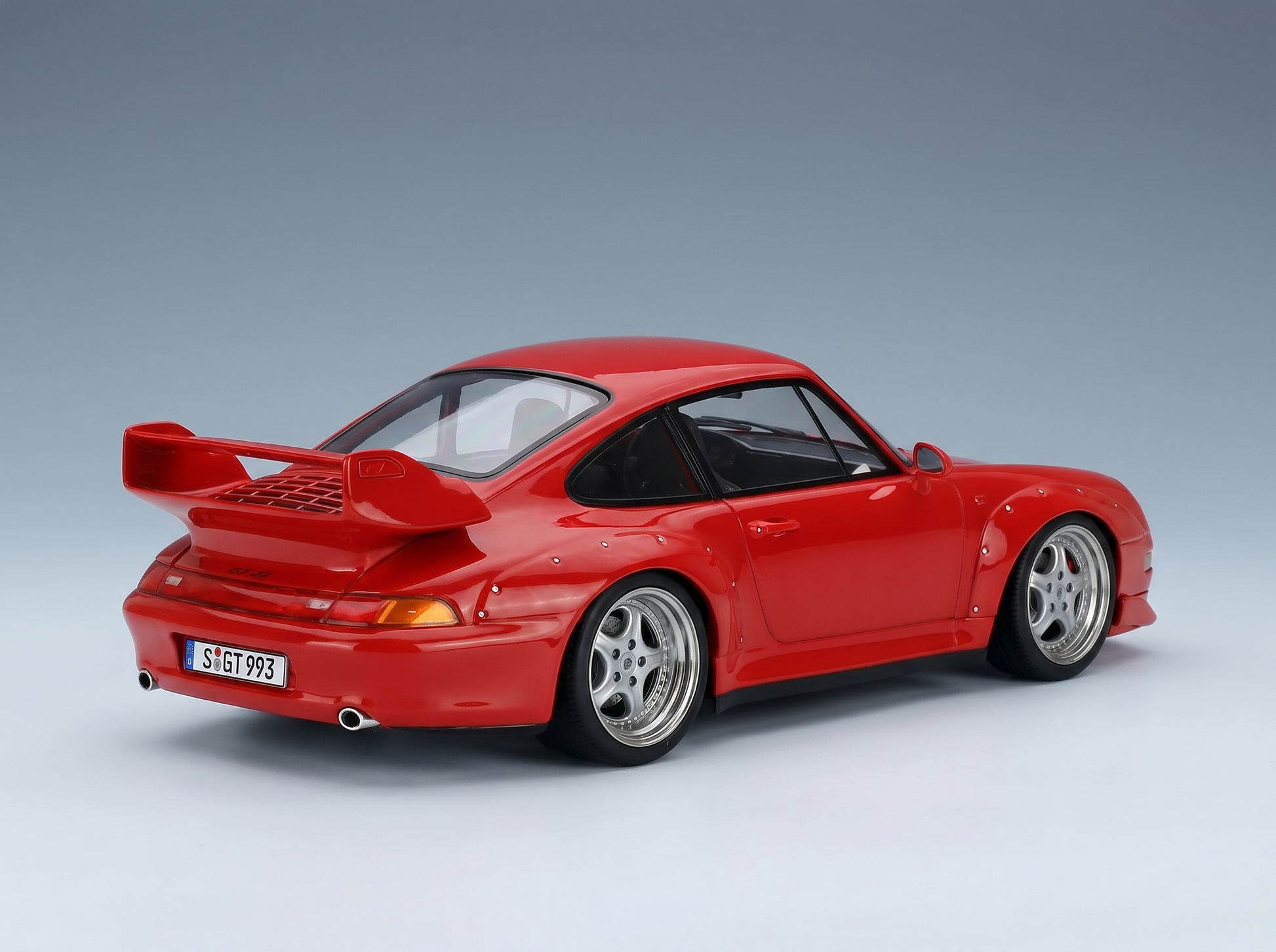Red Porsche 911 GT2 scale model car with wide body and rear wing, showcased by Vroomi