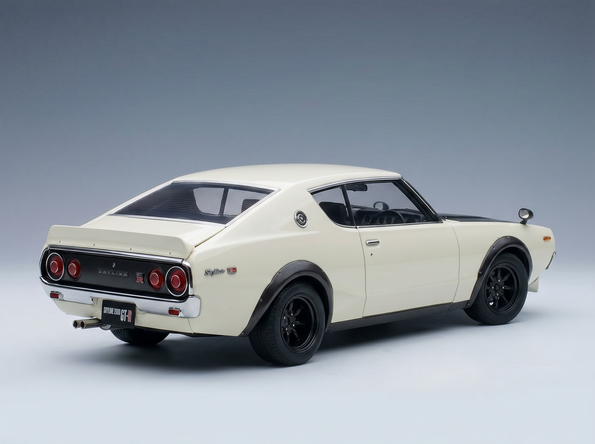 Cremefarbenes Nissan Skyline 2000 GT-R-Modellauto mit schwarzen Felgen, präsentiert von Vroomi für Sammler.