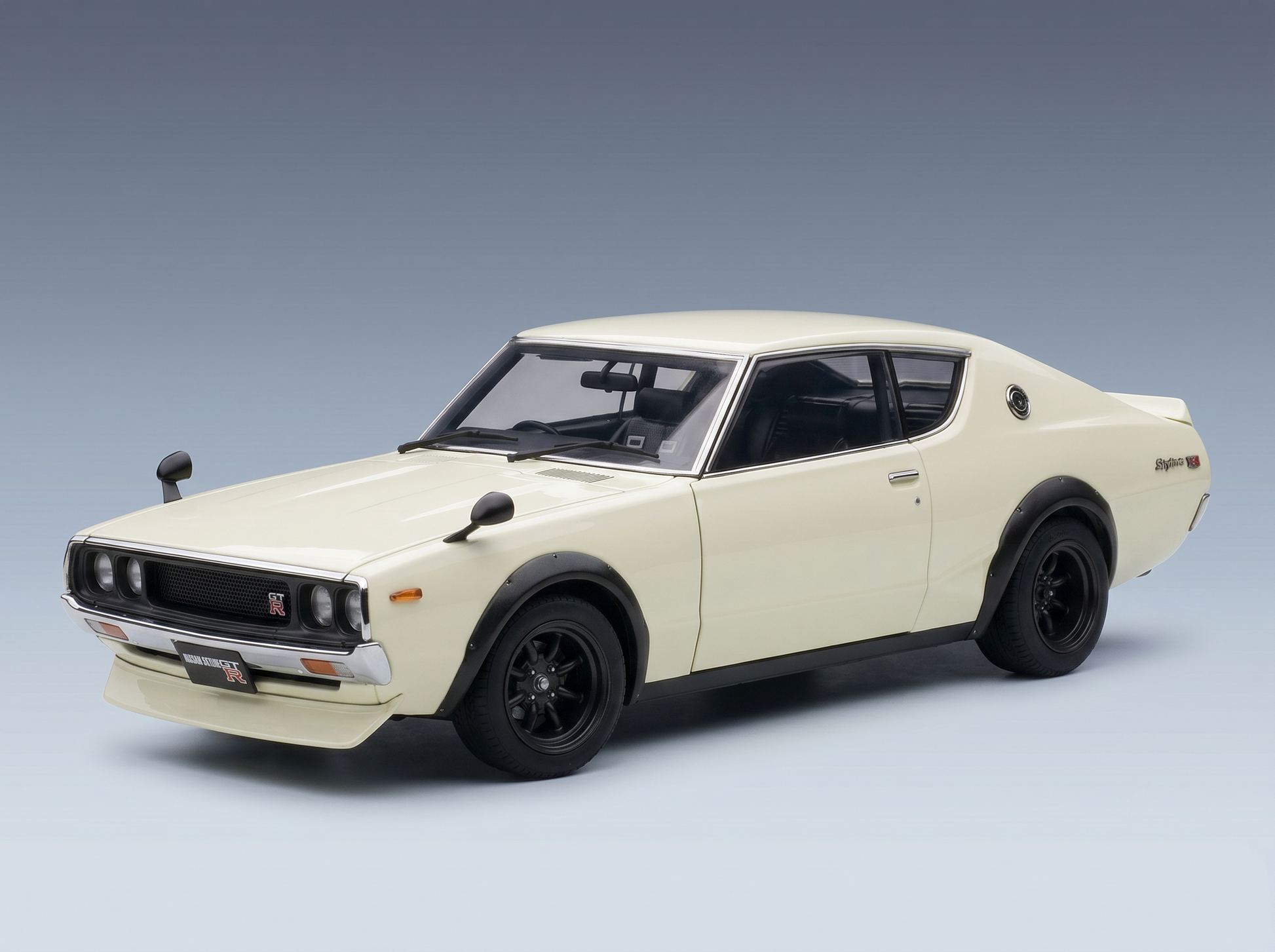 Cremefarbenes Nissan Skyline GT-R-Modellauto von Vroomi mit schwarzen Felgen und klassischem Design.