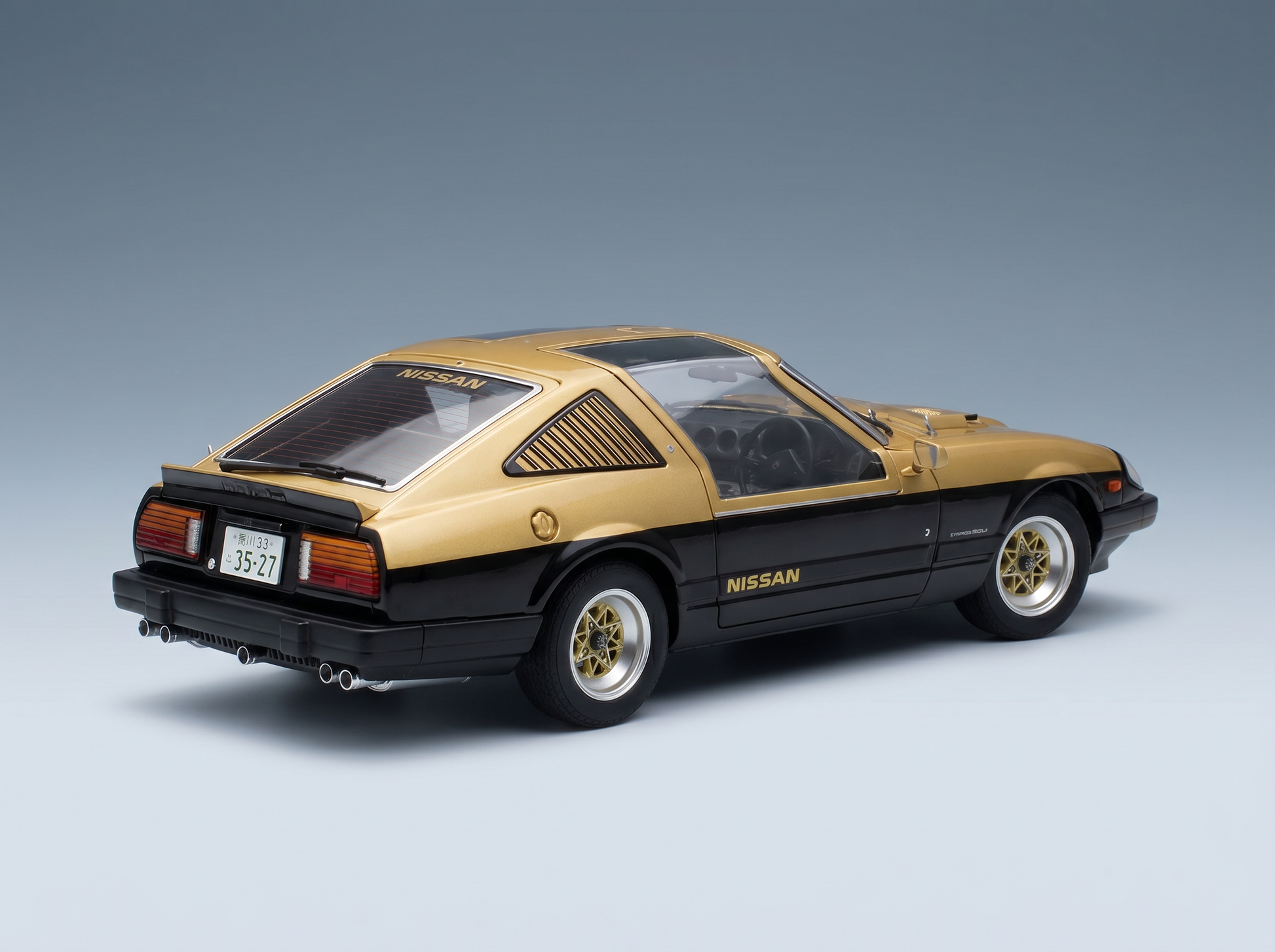 Gold-schwarzes Nissan-Modellauto von Vroomi, detailgetreue Druckguss-Nachbildung mit goldenen Rädern und Heckspoiler.