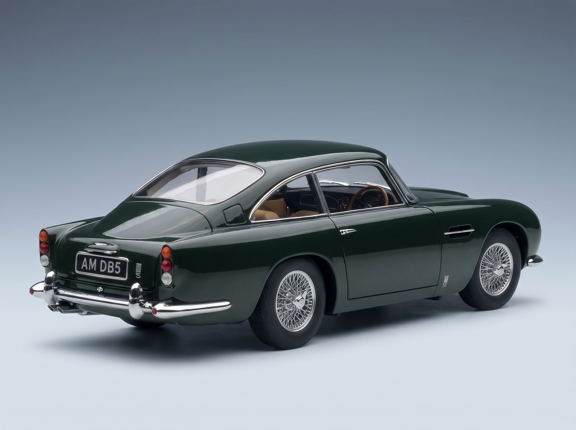 Green Aston Martin DB5 scale model car with wire wheels, showcased by Vroomi for collectors