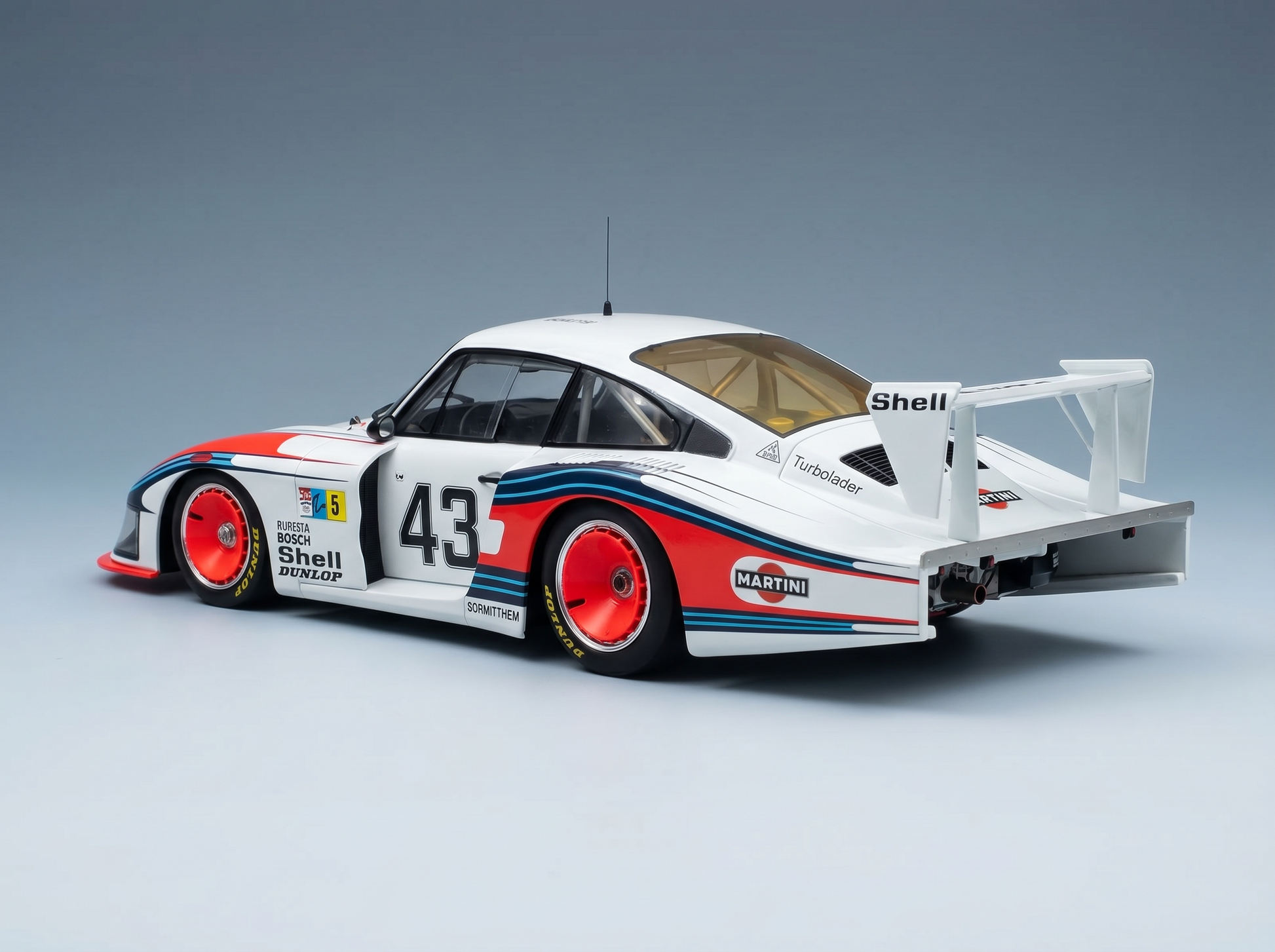 Porsche 935 Martini Racing Modellauto mit der Startnummer 43, roten Rädern und Shell-Logo — Vroomi