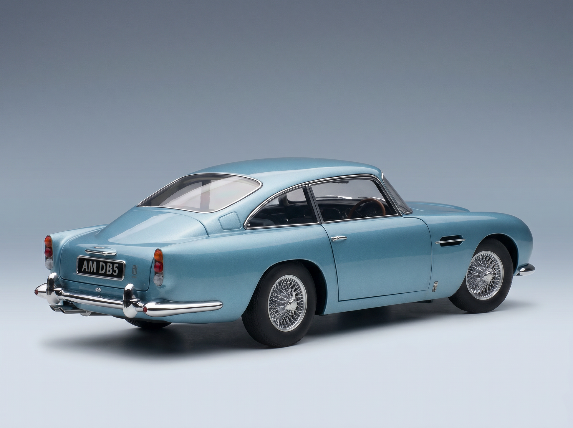 Blue Aston Martin DB5 scale model car from Vroomi, showcasing classic design and wire wheels.
