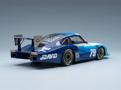 Blau-weißes Porsche-Modellauto im Maßstab 1:79 mit JDAVID-Logo, ausgestellt bei Vroomi