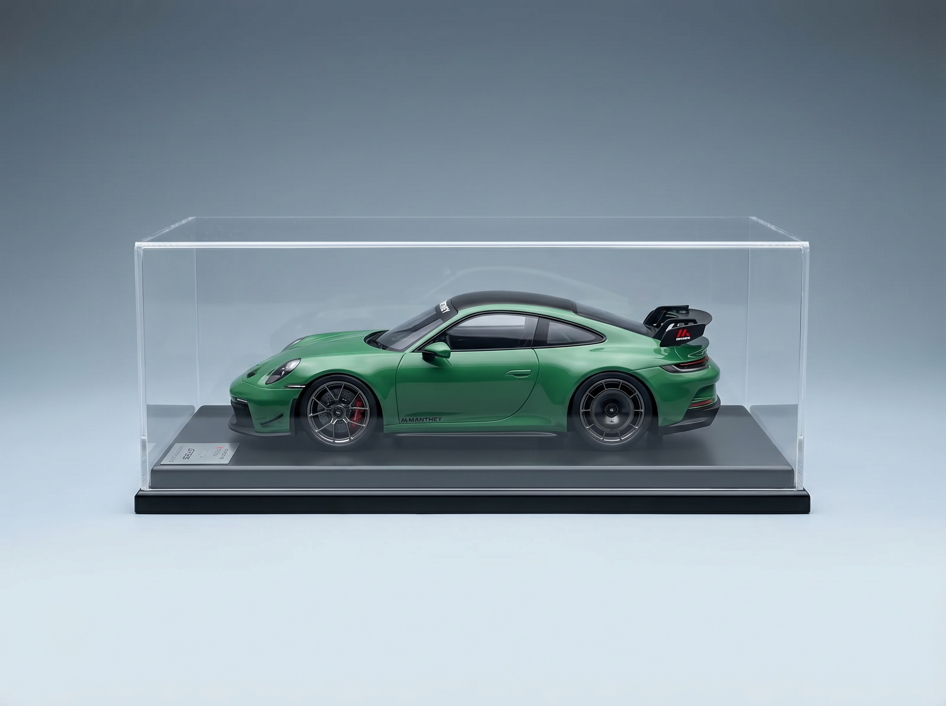 Grünes Porsche 911 GT3 RS-Modellauto in einer Vitrine von Vroomi, mit detailgetreuen Rädern und Heckflügel.