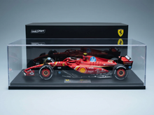 Rotes Ferrari-Modellauto in einer Vitrine mit HP- und Shell-Logos, zusammengestellt von Vroomi.