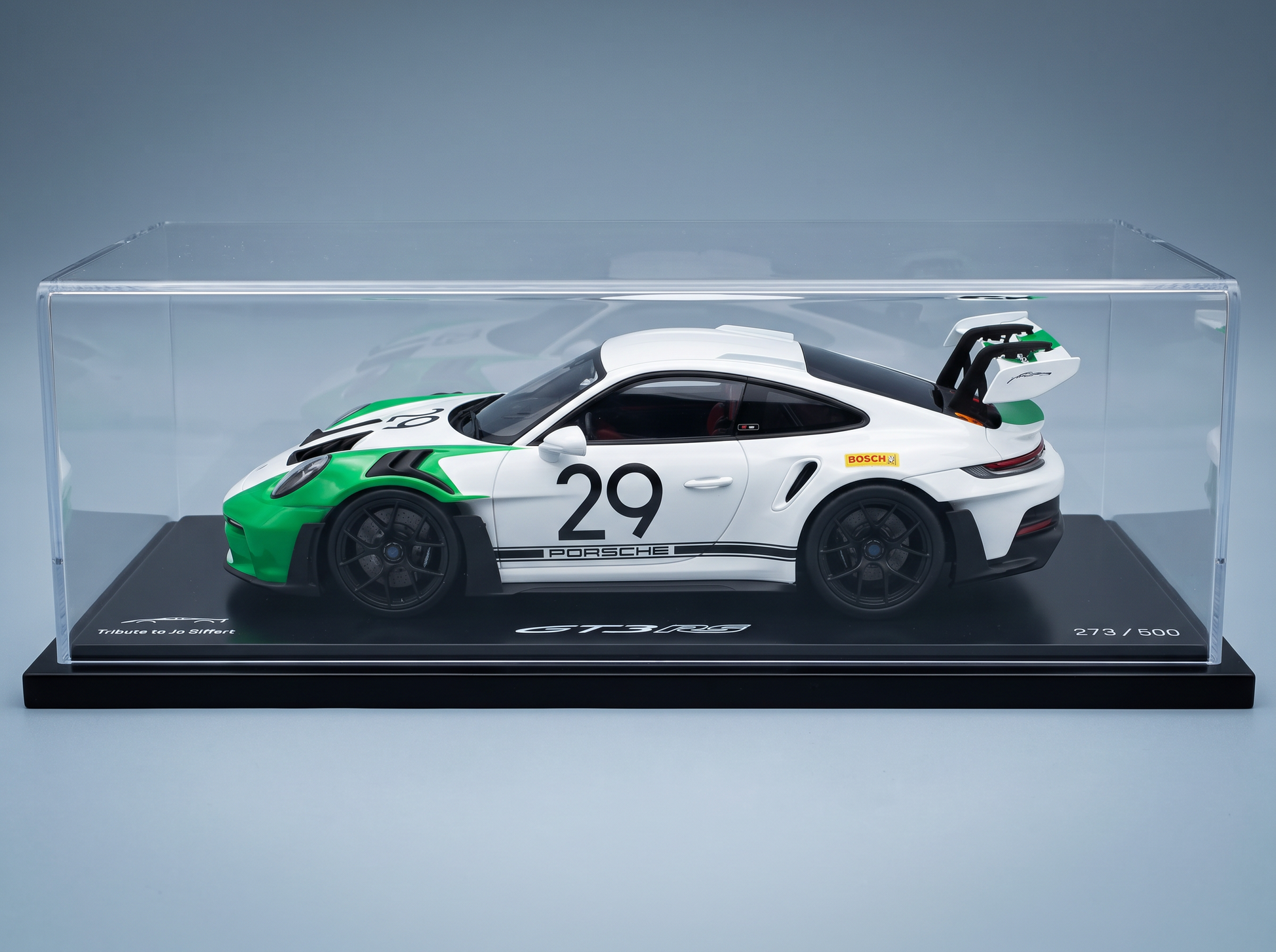 Maqueta de coche Porsche GT3 RS, en blanco y verde, n.º 29, homenaje a Jo Siffert, expuesta en una vitrina transparente — Vroomi