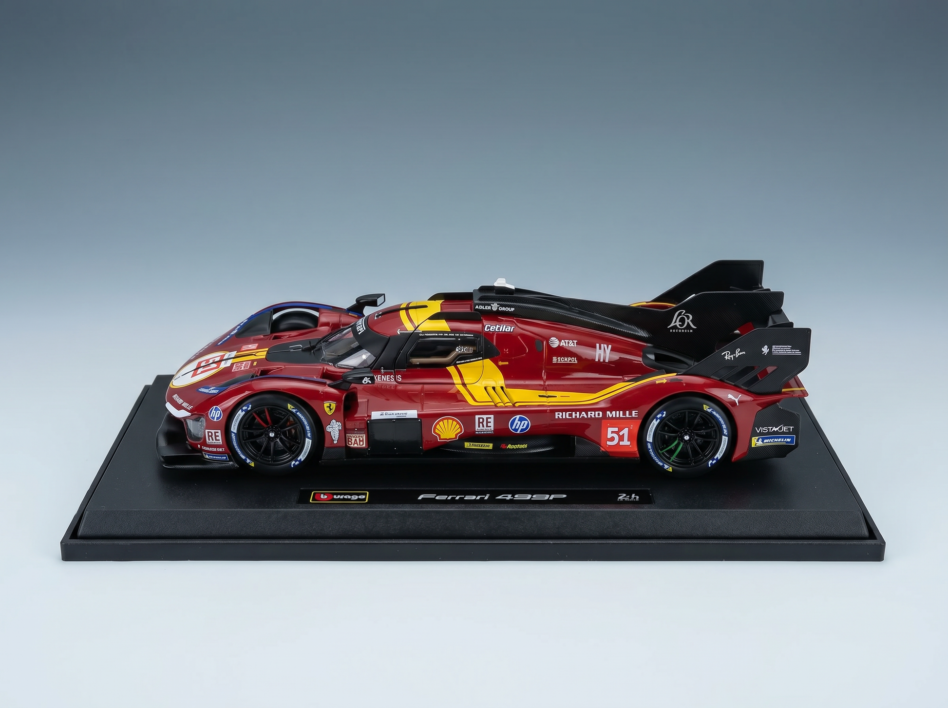 Red Ferrari 499P scale model car with racing decals, displayed on black base — Vroomi