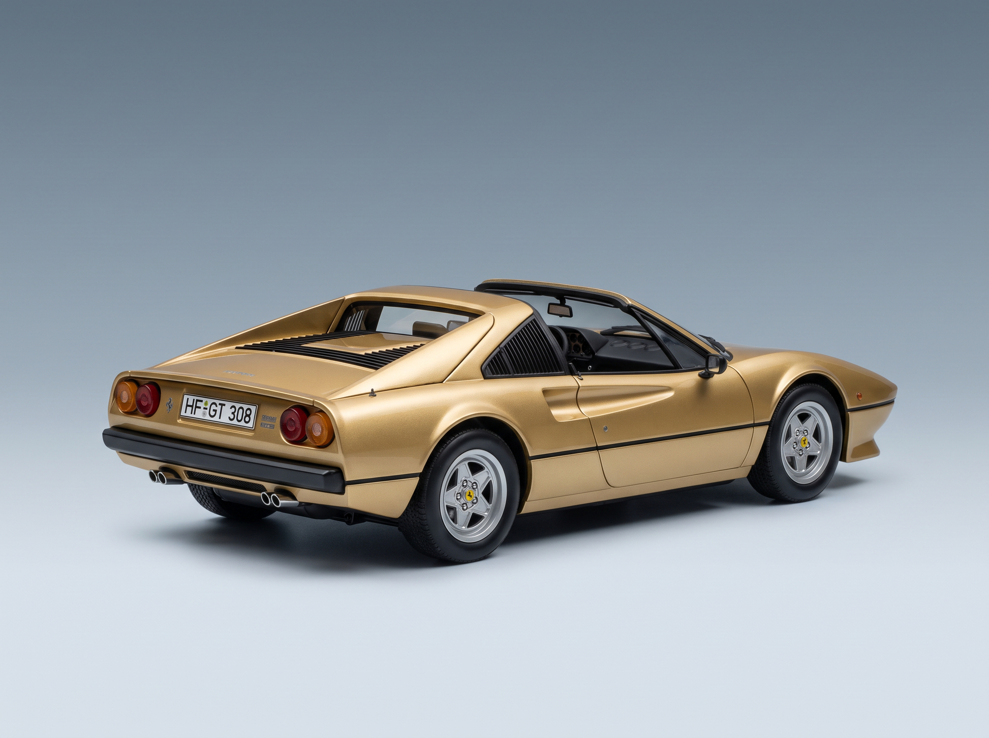 Maqueta a escala del Ferrari 308 GTS dorado de Vroomi, que destaca por el detallado diseño de la parte trasera y el estilo clásico de los coches deportivos.
