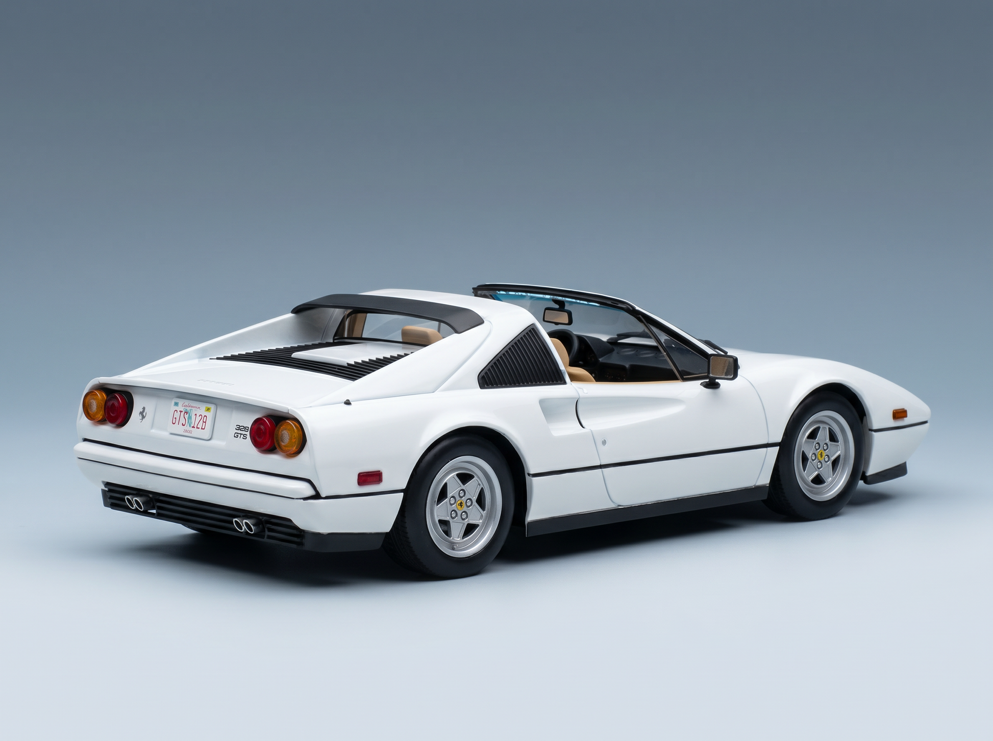 White Ferrari 328 GTS scale model car from Vroomi, detailed die-cast replica with tan interior and California plate
