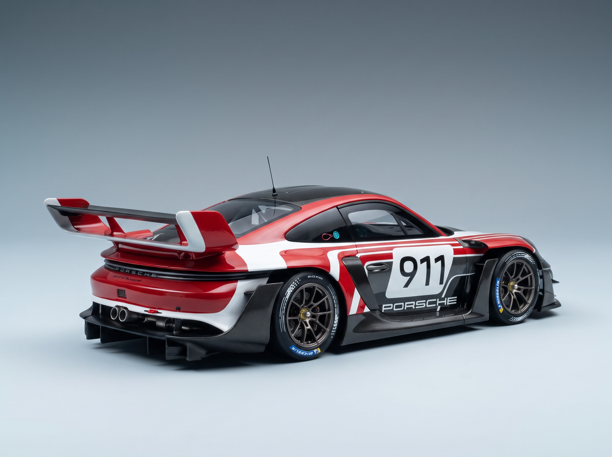 Maqueta a escala del Porsche 911 GT3 R de Vroomi, con una combinación de colores en rojo, blanco y negro, detalles en fibra de carbono y adhesivos de competición.
