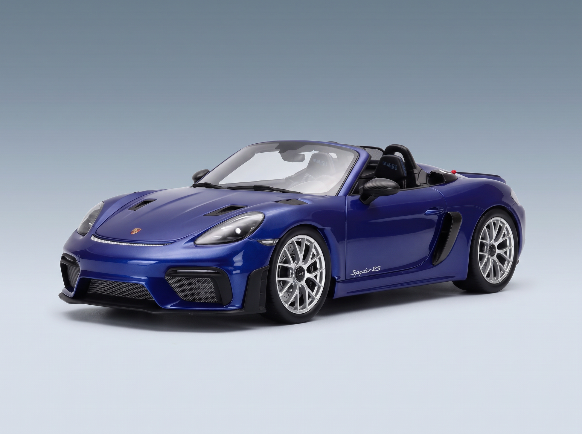 Maqueta a escala de un Porsche Spyder RS azul de Vroomi, con un diseño detallado y llantas de aleación.