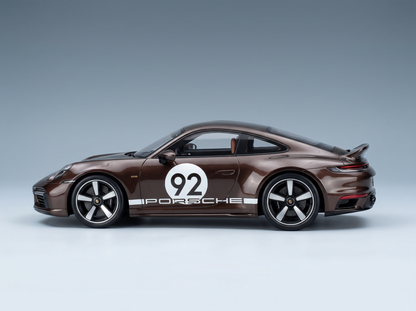 modellino , una Porsche 92 in scala, di colore marrone con strisce da gara bianche, presentata da Vroomi per i collezionisti.