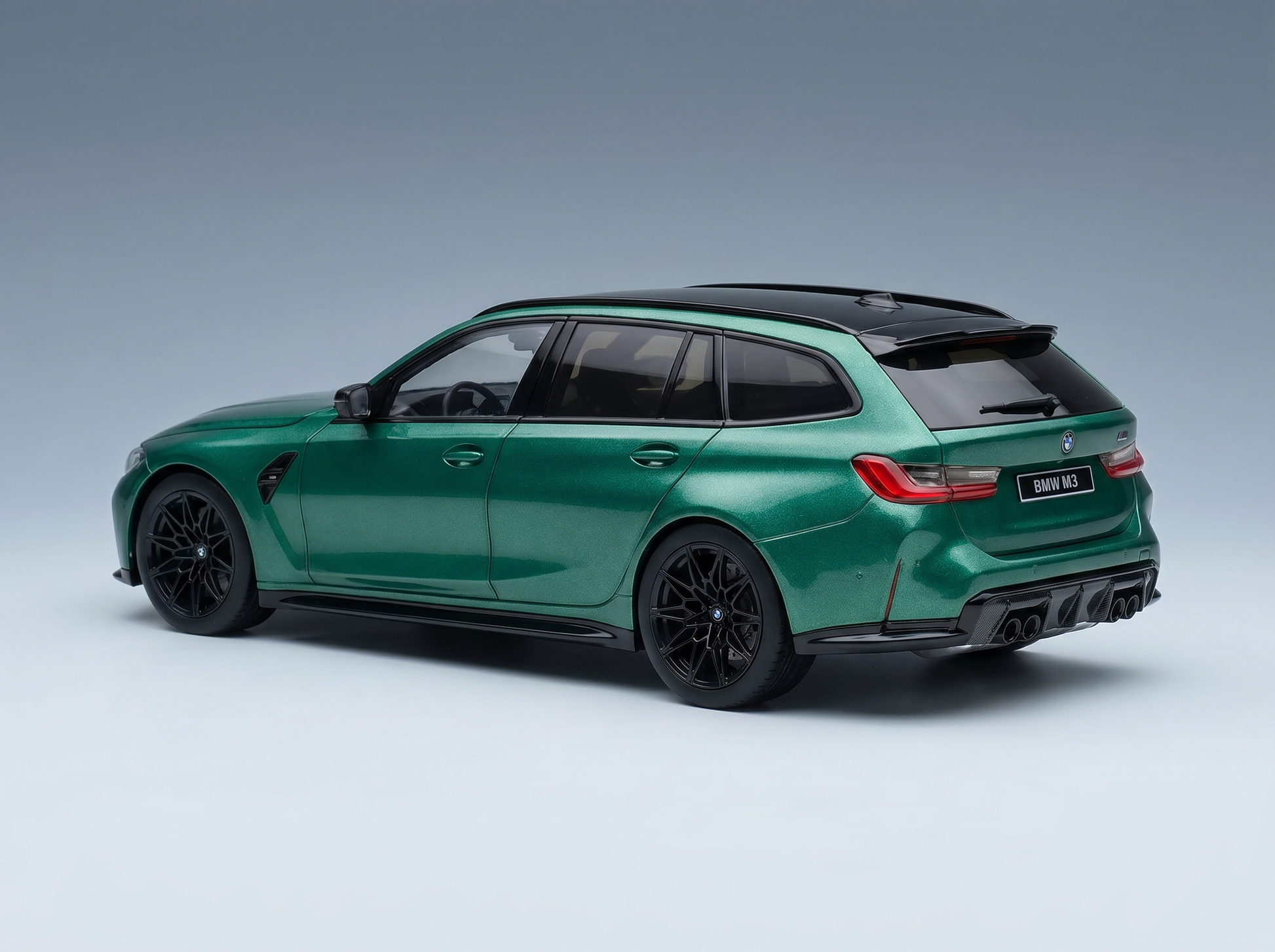 Green BMW M3 Touring scale model car with black rims, showcased by Vroomi for collectors.
