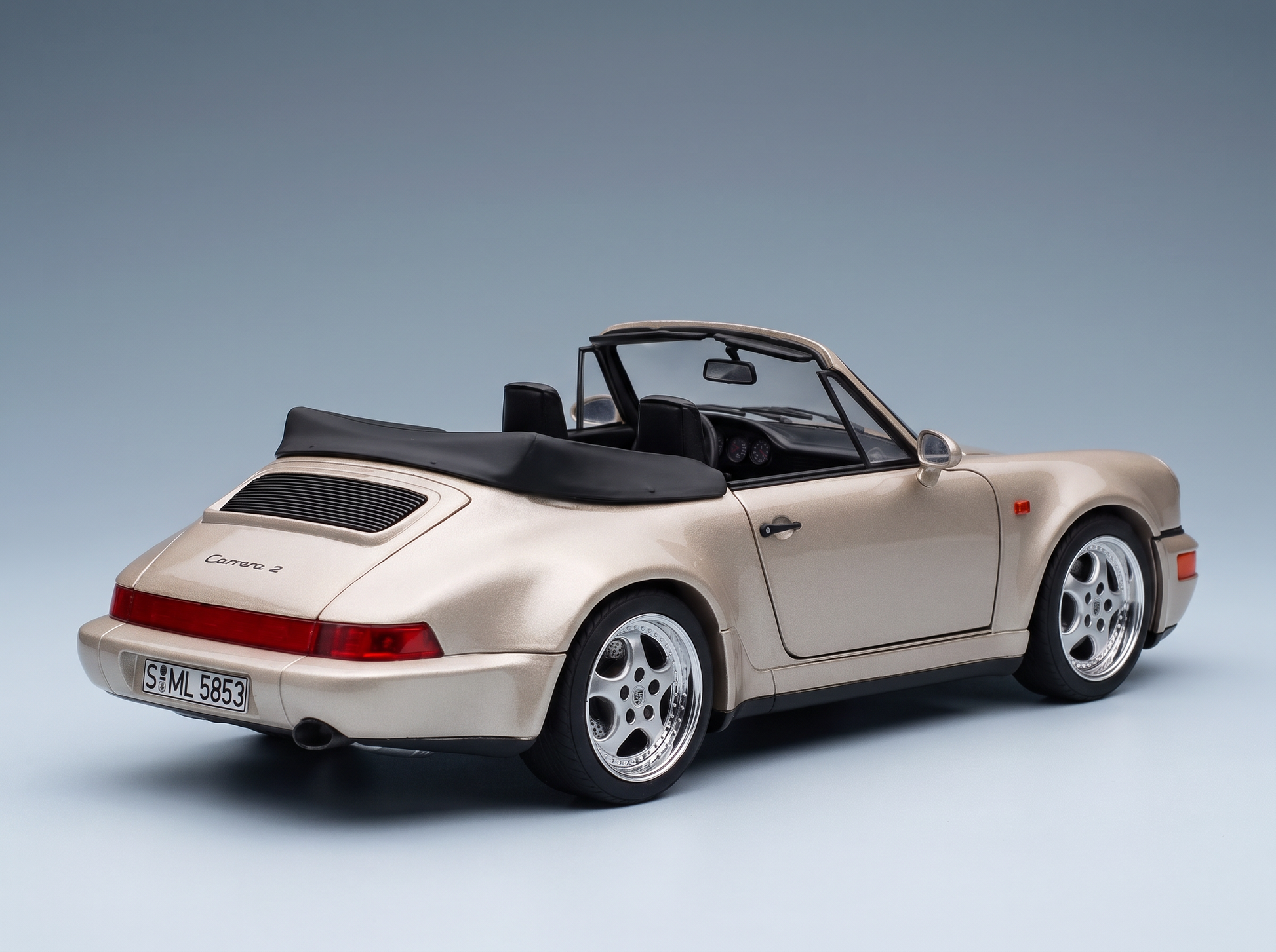 Beige Porsche 911 Carrera 2 scale model car with black soft top, showcased by Vroomi for collectors.