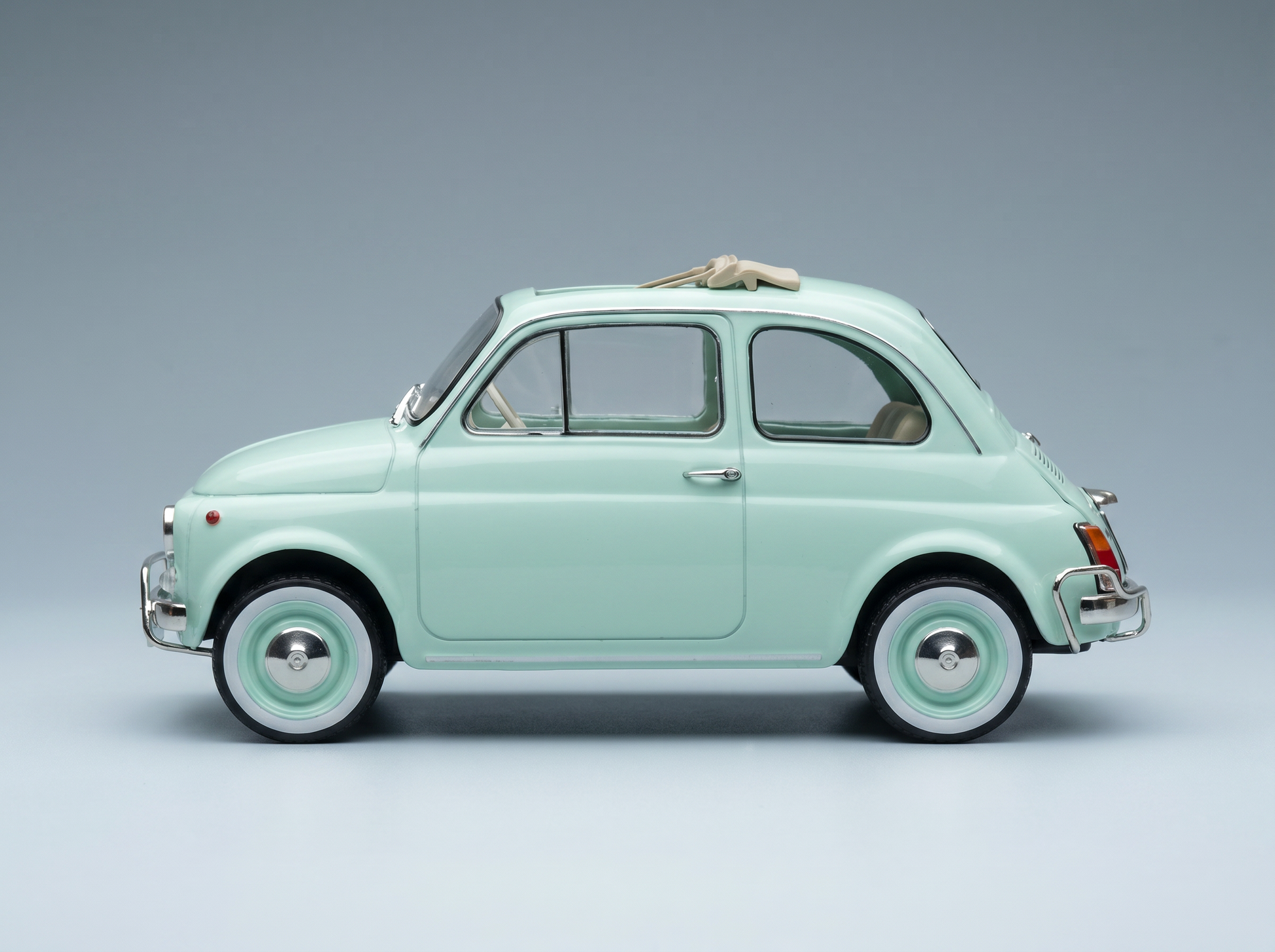 Maqueta de coche en color verde menta con un diseño clásico, presentada por Vroomi para coleccionistas.