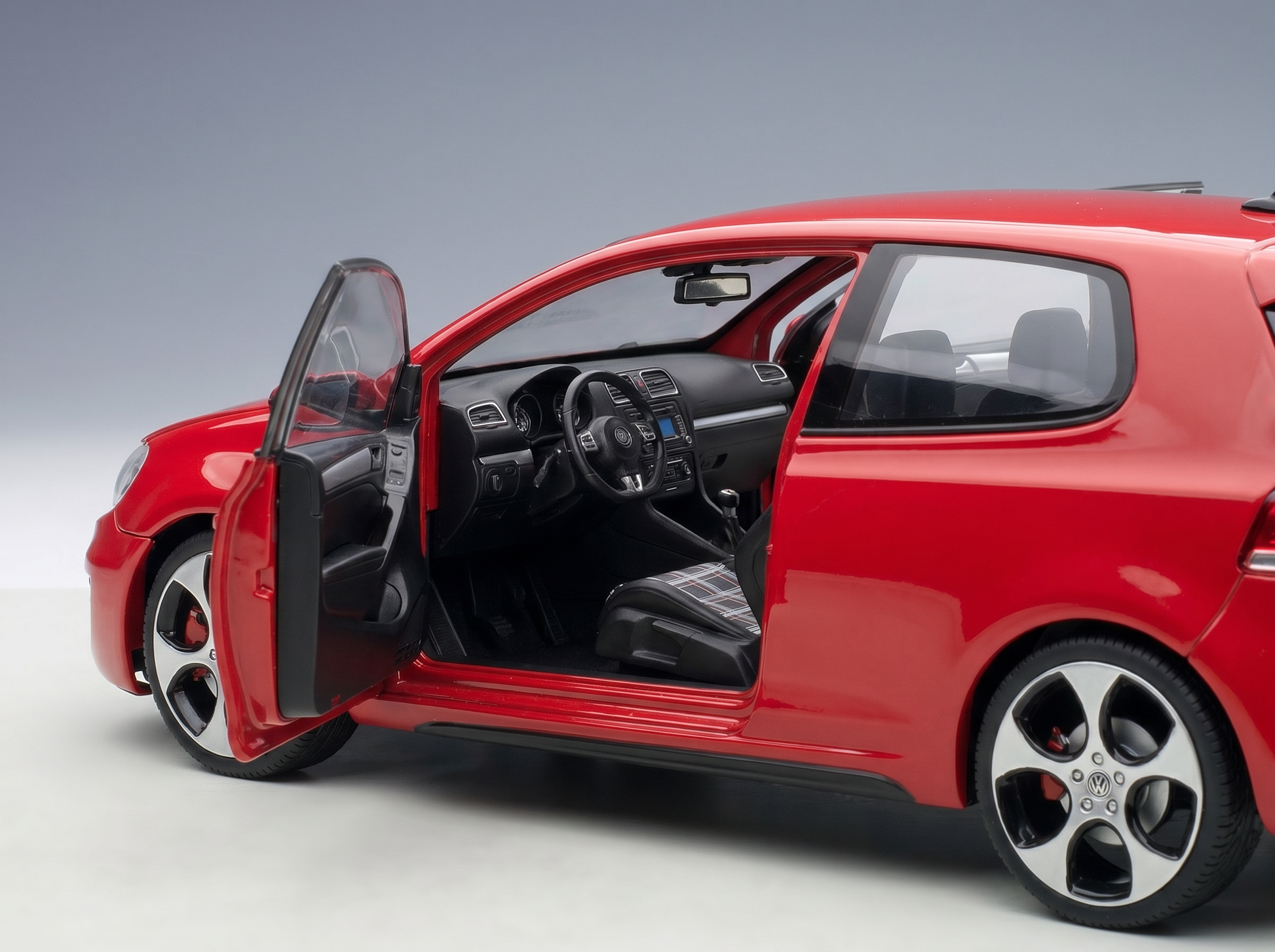 Coche a escala rojo con las puertas abiertas e interior detallado, de Vroomi