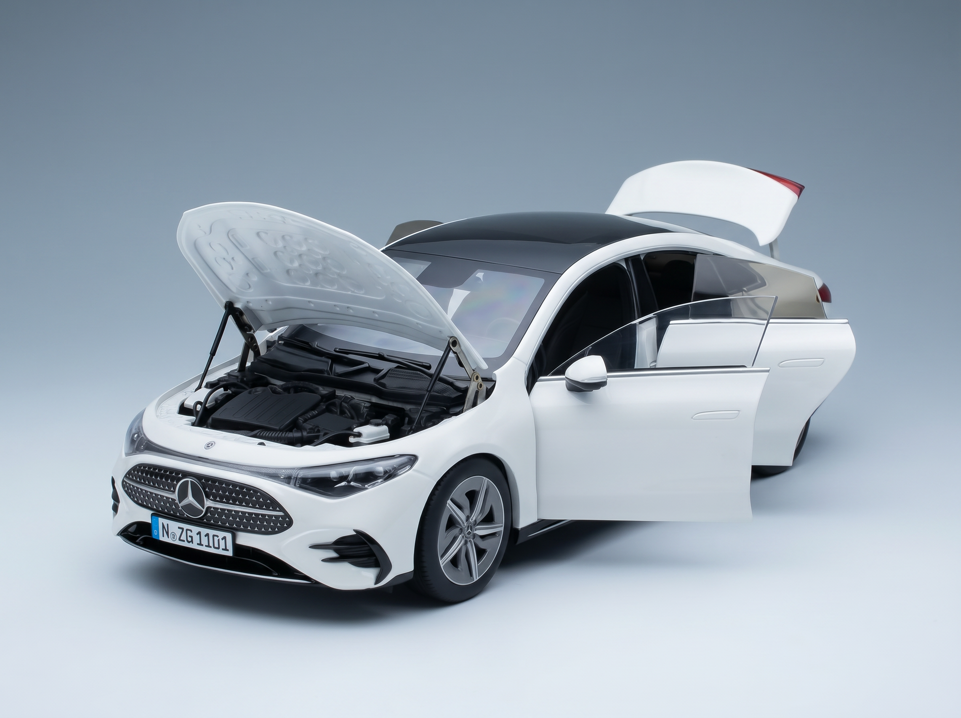 Weißes Mercedes-Benz-Modellauto mit geöffneten Türen und Motorhaube sowie detailgetreuem Motor, von Vroomi