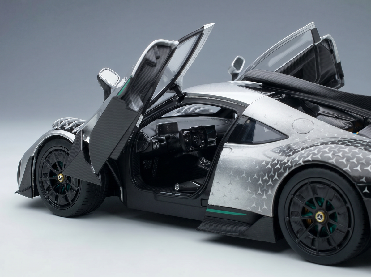 Silver scale model car with open doors, detailed interior, and Vroomi branding for collectors.
