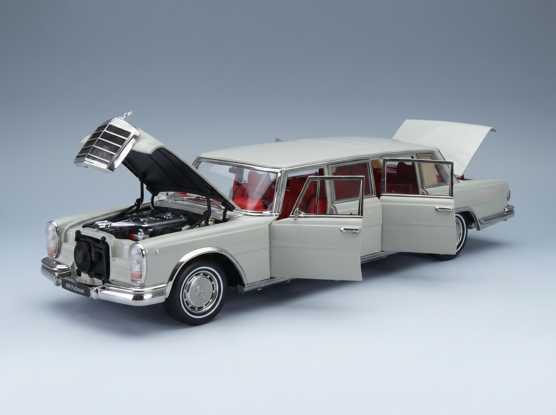 Wit schaalmodel van een Mercedes 600 Pullman met open deuren en motorkap, gepresenteerd door Vroomi