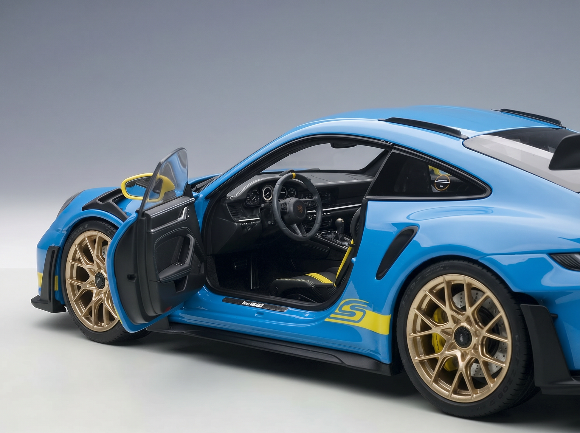 Blue scale model car with open doors, gold wheels, yellow accents — Vroomi collector replica