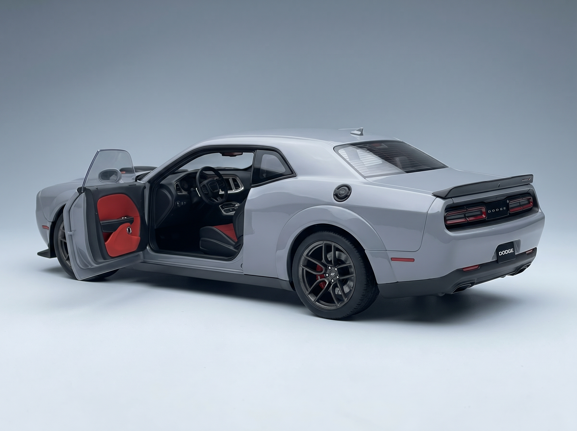 Gray Dodge Challenger scale model car with open door, red interior, at Vroomi