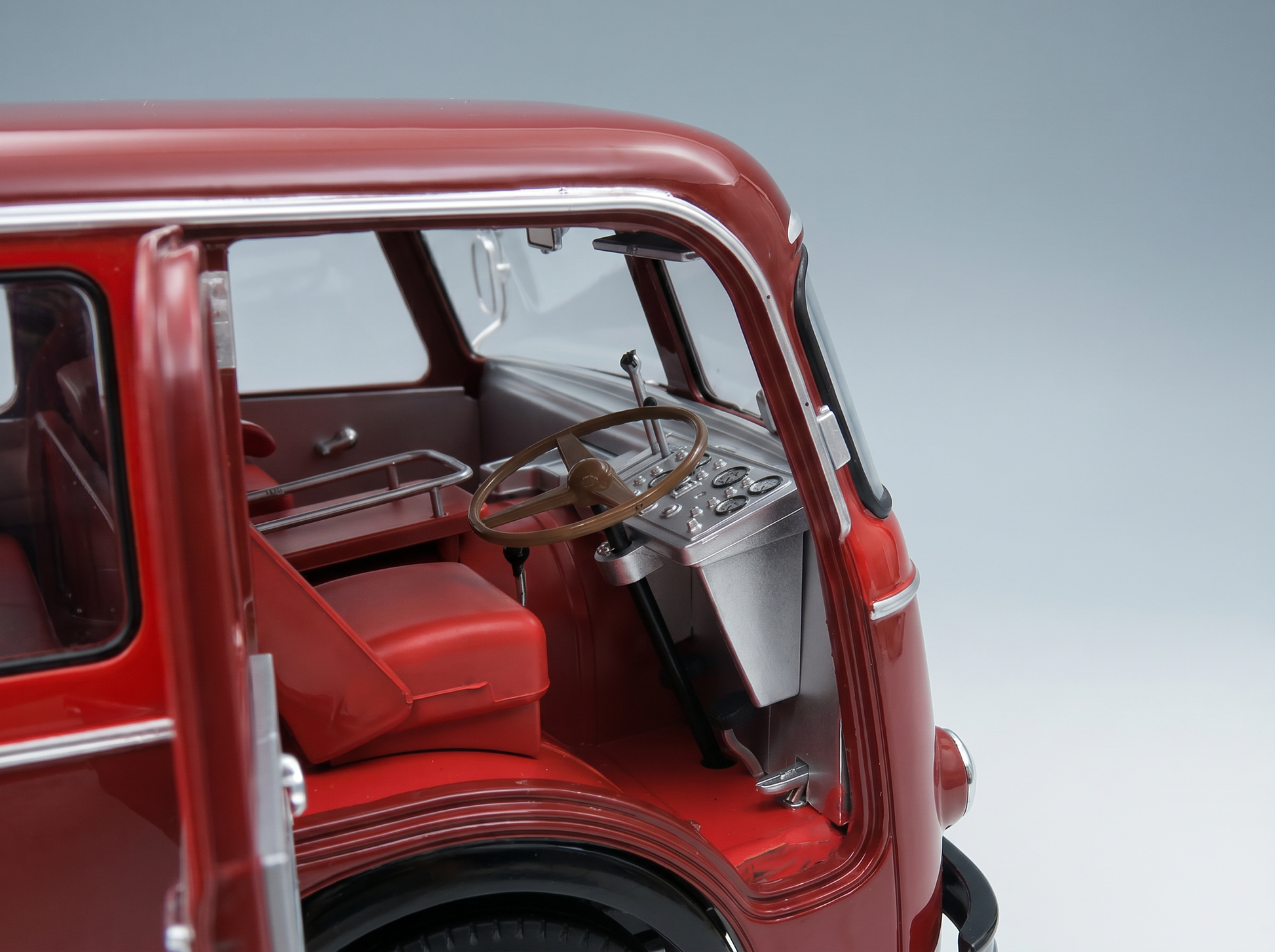 Red scale model car interior with detailed dashboard and steering wheel, showcased by Vroomi
