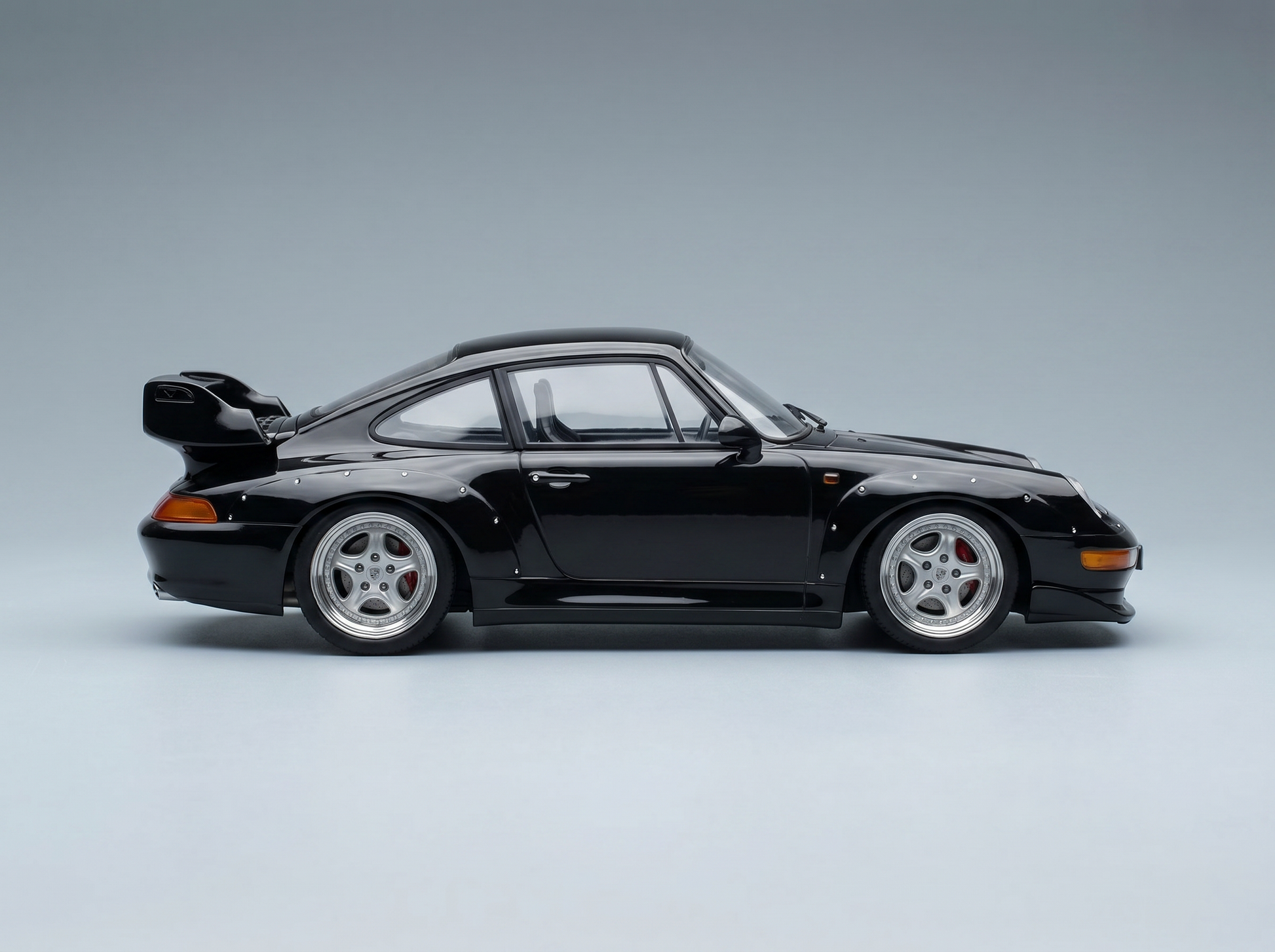 Black Porsche 911 GT2 scale model car with wide body, rear wing, and silver wheels from Vroomi