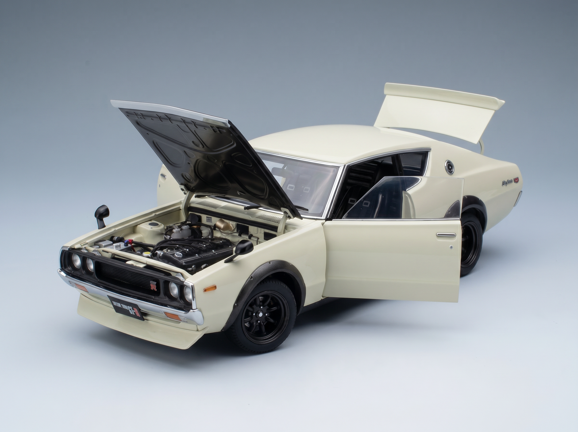 Cremefarbenes Nissan Skyline GT-R-Modellauto mit geöffneter Motorhaube und Türen sowie detailgetreuem Motor von Vroomi